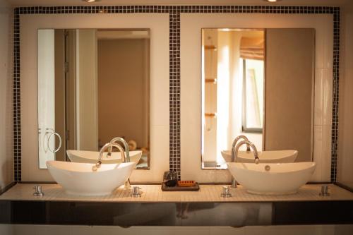a bathroom with three sinks and two mirrors at Kata Prime in Kata Beach
