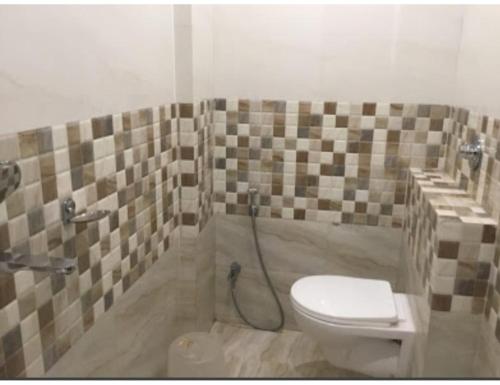a bathroom with a toilet and a shower at Hotel City Inn, Gaya in Gaya
