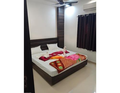 a bedroom with a bed with clothes on it at Hotel City Inn, Gaya in Gaya