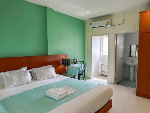 um quarto com uma cama com duas toalhas em Grandma Kaew House em Chiang Rai