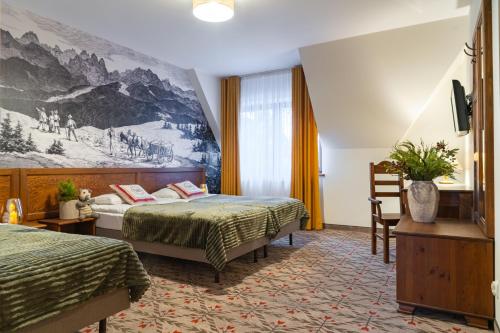 ザコパネにあるPensjonat Maria 5のベッド2台が備わる客室で、壁には絵画が飾られています。