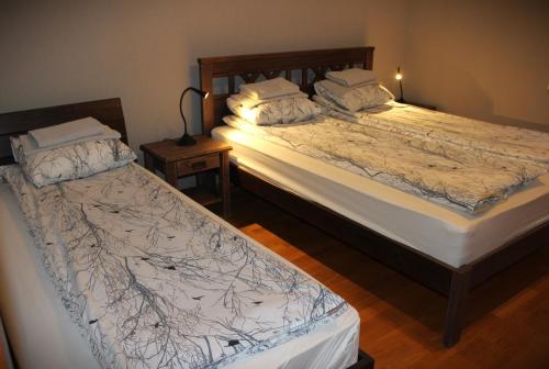 two twin beds in a bedroom with a night stand at Raja Lake House in Raja
