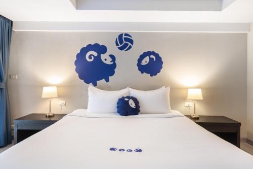 a bed with blue sheep stickers on the wall at Kokotel Phuket Patong - SHA Extra Plus in Patong Beach
