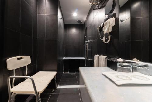 a black bathroom with a bench and a sink at Andalus Habitat Hotel in Jeddah