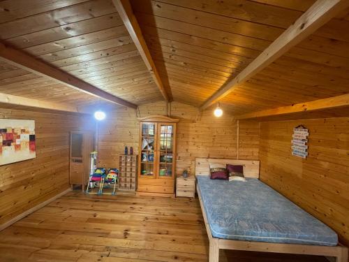 Habitación con cama en una cabaña de madera en La Marciana - piscina pista tenis futbol y baloncesto privado - Bungalow externo independiente, en Chiclana de la Frontera