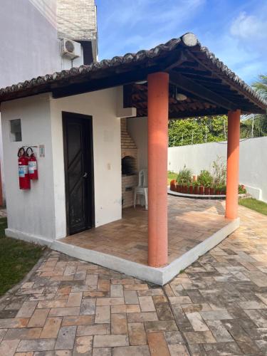 una pérgola en un patio junto a una casa en Apartamento Ocean View Tabatinga, en Nísia Floresta