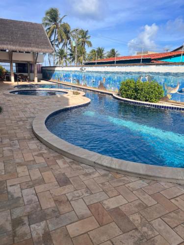uma piscina num resort com um mural em Apartamento Ocean View Tabatinga em Nísia Floresta