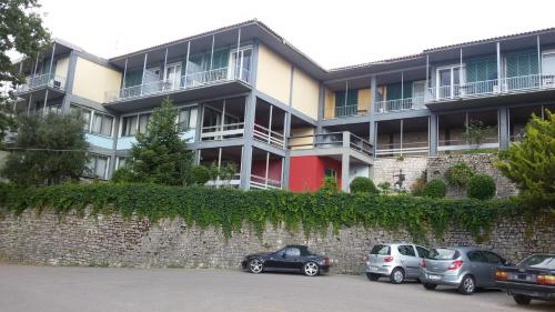 a large building with cars parked in front of it at Theoxenia Hotel in Andritsaina