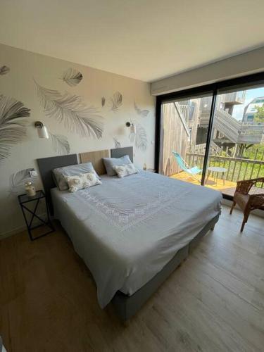 une chambre avec un lit et une grande fenêtre dans l'établissement Vue mer et plage appartement Les Minimes, à La Rochelle