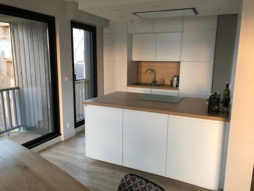 une cuisine avec des armoires blanches et un comptoir dans l'établissement Vue mer et plage appartement Les Minimes, à La Rochelle