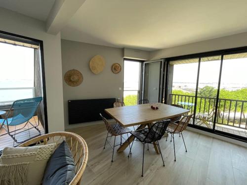 une salle à manger avec une table et des chaises et un balcon dans l'établissement Vue mer et plage appartement Les Minimes, à La Rochelle