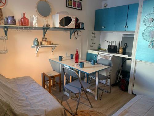 una cucina con tavolo e sedie in una stanza di La Mongie Tourmalet, 2 a 4 couchages, pied de pistes, station de ski a Bagnères-de-Bigorre
