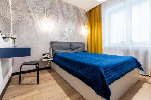 a bedroom with a bed with a blue blanket on it at Apartamenty PREMIUM, Faktura VAT, Źródłowa CENTRUM PARTER GROUND FLOOR PARKING SUPER LOKALIZACJA TWO BEDROOMS KITCHEN 50 M2 in Kielce