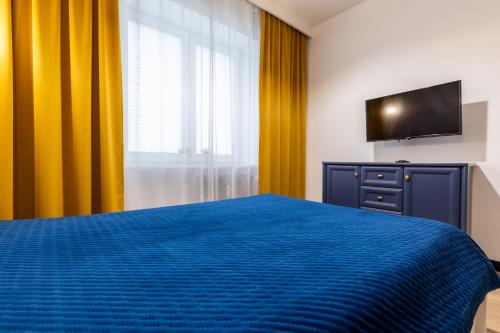 a bedroom with a blue bed and a television at Apartamenty PREMIUM, Faktura VAT, Źródłowa CENTRUM PARTER GROUND FLOOR PARKING SUPER LOKALIZACJA TWO BEDROOMS KITCHEN 50 M2 in Kielce