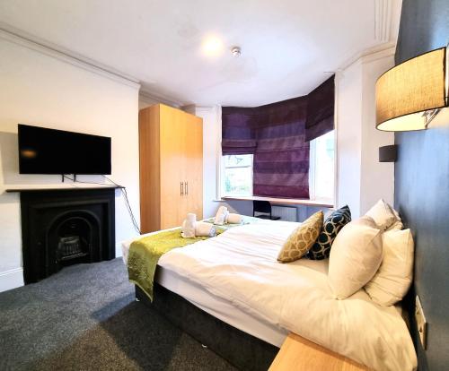 a bedroom with a bed with a fireplace and a television at Bath Road Studios in Swindon