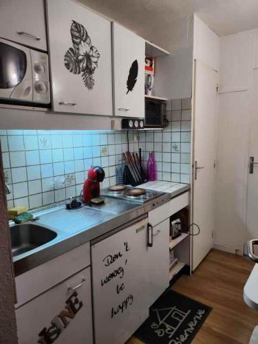 une cuisine avec un évier et un plan de travail dans l'établissement La Mongie 6 couchages pied de pistes, à La Mongie