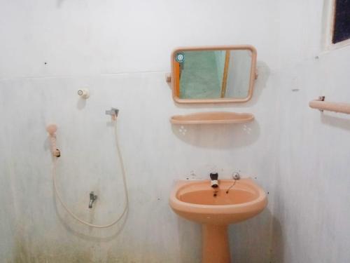 a bathroom with a toilet and a mirror on the wall at Arachchi Guest House in Mirissa