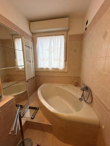 a bathroom with a large tub and a window at Cà Savoia in Bologna