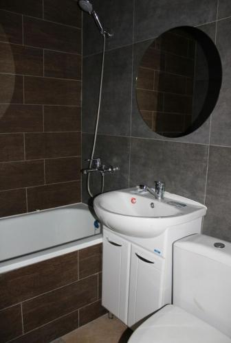 uma casa de banho com um lavatório, um WC e um espelho. em Амстердам em Petropavl
