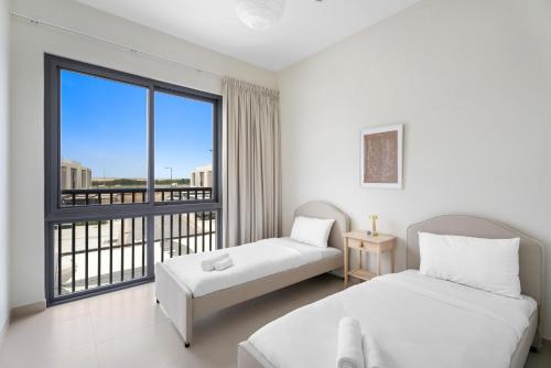 um quarto com 2 camas e uma grande janela em Lovely 3BR Villa in Dubai EXPO em Dubai
