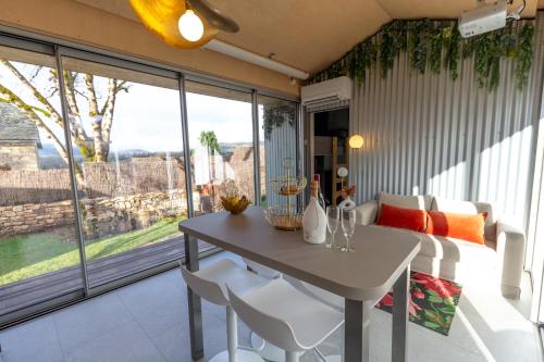 a room with a table and chairs and a bed at Le Dourdou del traouc in Bozouls
