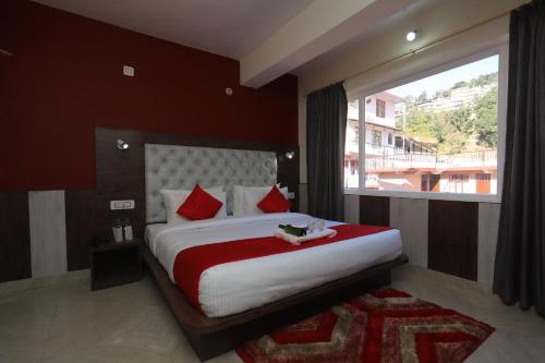 a bedroom with a large bed with a large window at The Nest with open rooftop cafe Mecleodganj in Dharamshala