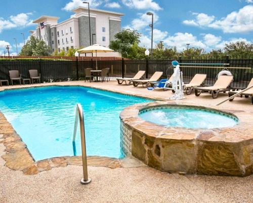 a large swimming pool with a stone tub at Sleep Inn & Suites New Braunfels in New Braunfels