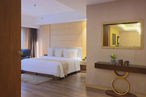 - une chambre d'hôtel avec un lit et un miroir dans l'établissement Best Western Plus Metro Clark, à Ángeles