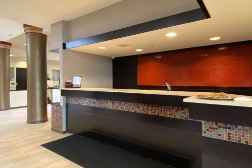 a restaurant with a counter with a plate of food at Wyndham Minneapolis South Burnsville in Burnsville