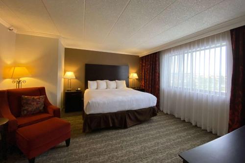 a hotel room with a bed and a chair at Wyndham Minneapolis South Burnsville in Burnsville