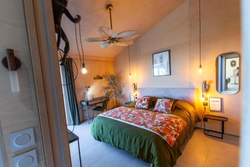 une chambre avec un lit et un ventilateur de plafond dans l'établissement L'Alrance del traouc, à Bozouls