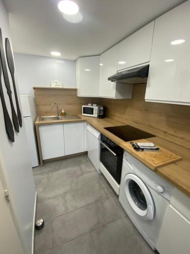 a kitchen with white cabinets and a washing machine at Appartement Sol y Mar in Saint-Aygulf
