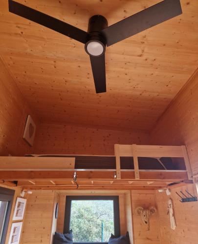a ceiling fan in a room with a window at Tiny House Loul Algarve no1 in Loulé