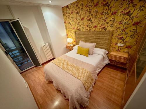 a small bedroom with a bed with a yellow pillow at Balcón del Rosal in Oviedo