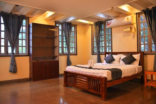 a bedroom with a bed in a room with windows at Revive Inn Pondy - Rooms & Villa in Puducherry