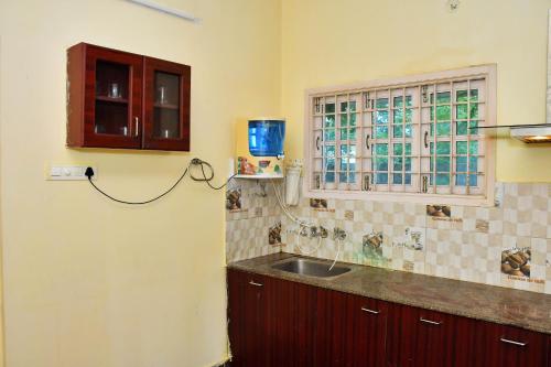 a kitchen with a sink and a window at Revive Inn Pondy - Rooms & Villa in Pondicherry
