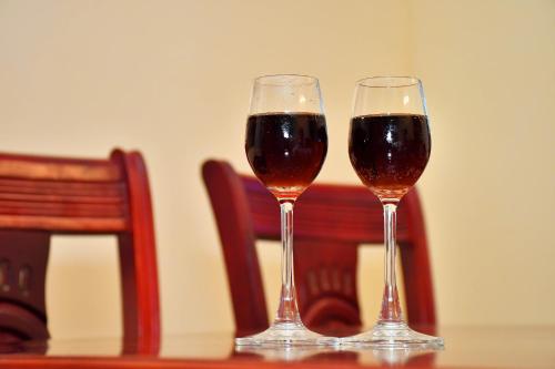 two glasses of wine sitting on a table at Revive Inn Pondy - Rooms & Villa in Puducherry