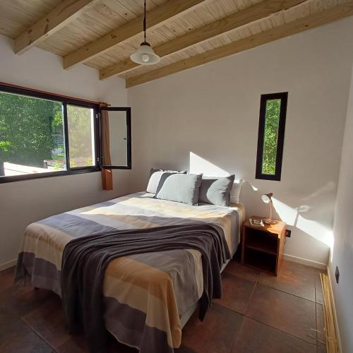 a bedroom with a large bed in a room with windows at Ruca Reuemn in Mar del Plata