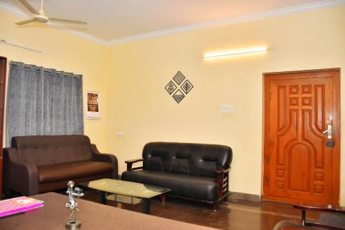 a waiting room with leather chairs and a door at Revive Inn Pondy - Rooms & Villa in Puducherry