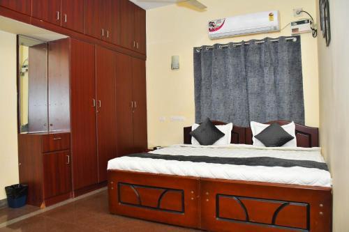 a bedroom with a bed with wooden cabinets and a window at Revive Inn Pondy - Rooms & Villa in Puducherry