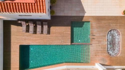 a building with a swimming pool and a tub at Hotel Loar Ferreries in Ferreries