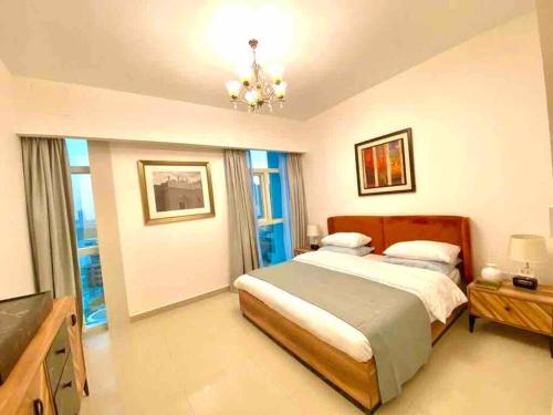 a bedroom with a large bed and a chandelier at Sea View - 2BHK - Al Reem Island 6ppl Free Transportation from AD Airport in Abu Dhabi