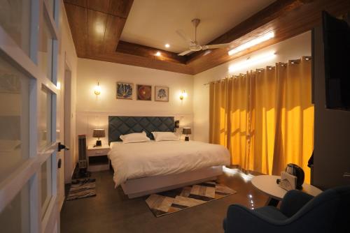 - une chambre avec un lit et un rideau jaune dans l'établissement Hotel Evara, à Mussoorie
