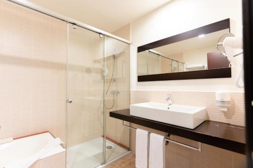 uma casa de banho com um lavatório e um chuveiro em Hotel Loar Ferreries em Ferreries