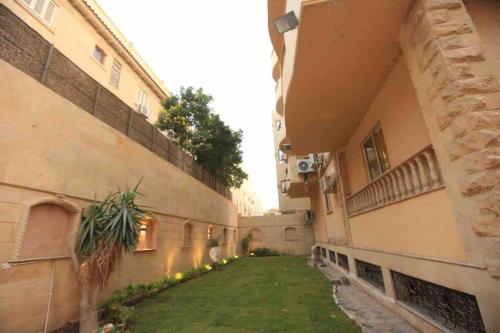 une allée entre deux bâtiments avec une cour d'herbe dans l'établissement Munir`s residence 2, au Caire