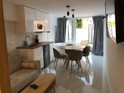 eine Küche und ein Wohnzimmer mit einem Tisch und Stühlen in der Unterkunft Suite PLAYAMAR con jacuzzi in Torremolinos