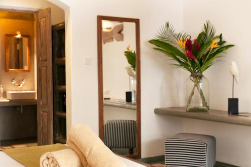 uma sala de estar com um espelho e um vaso de flores em Nirbana Retreat em Ahangama
