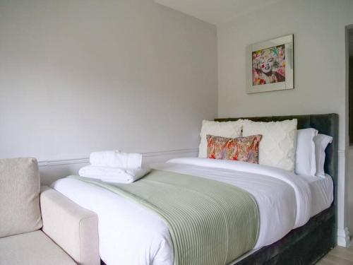 a bedroom with a large white bed and a couch at Super comfy apartment in prime central London in London