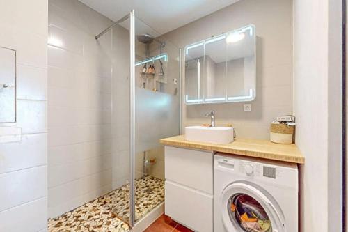 W łazience znajduje się pralka i umywalka. w obiekcie Appt avec Parking près de La Seine Musicale w mieście Boulogne-Billancourt