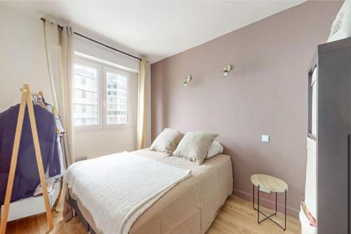 1 dormitorio con cama y ventana en Appt avec Parking près de La Seine Musicale, en Boulogne-Billancourt